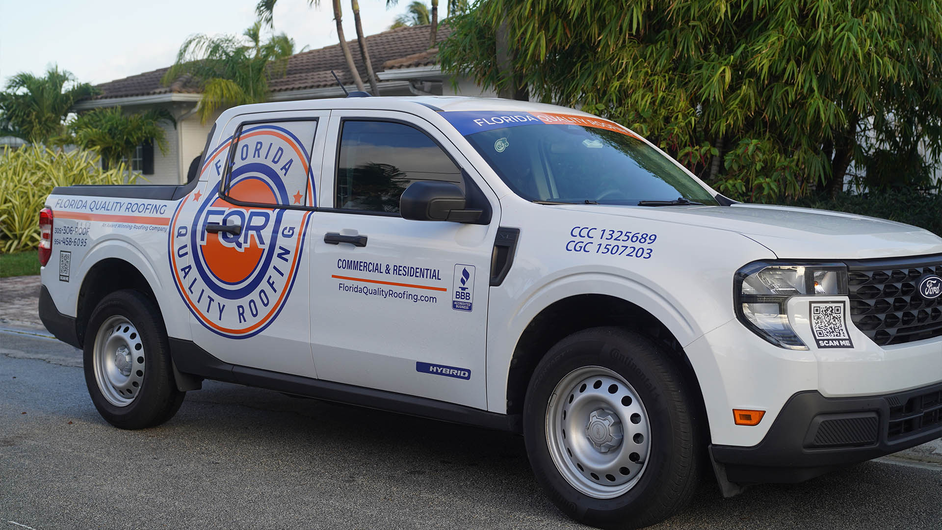 White Ford pickup truck with Florida Quality Roofing branding parked on a residential street, large circular logo on the side and a roof banner reading Florida Quality Roofing.