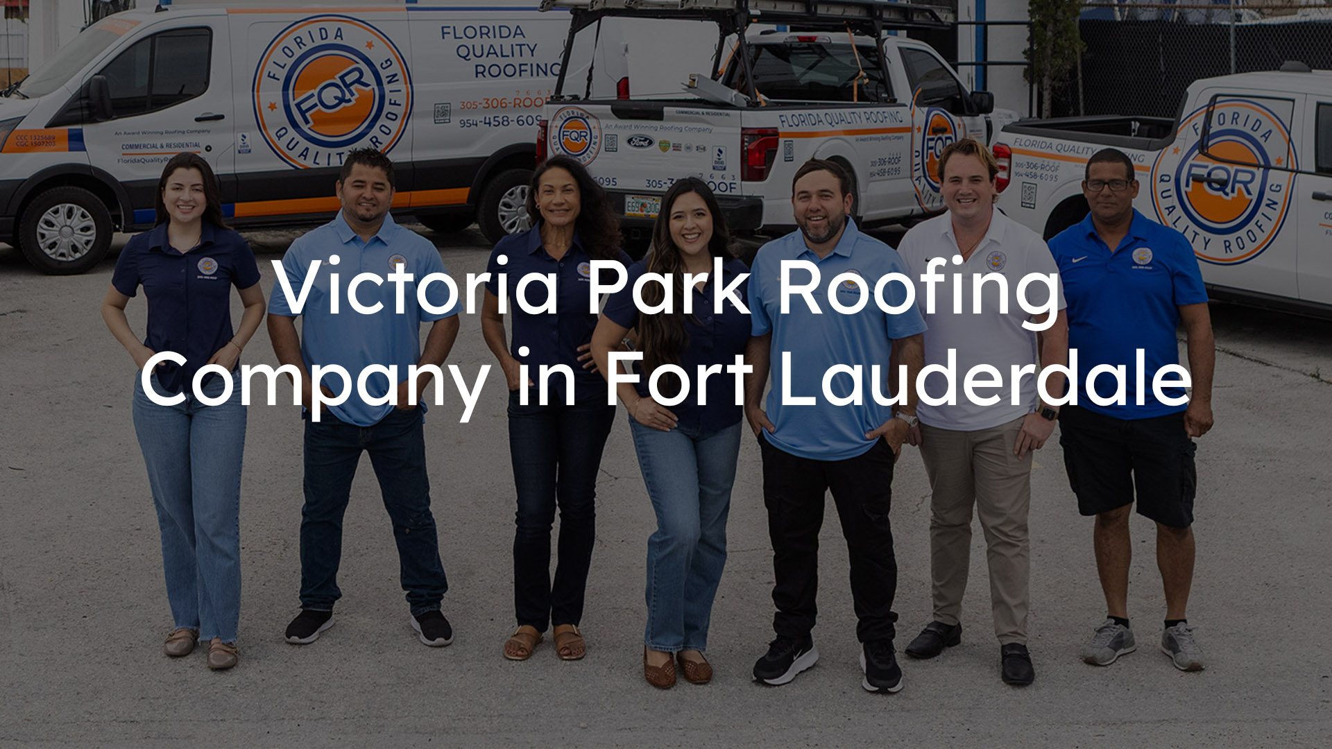 Group of eight roofing company staff posing in front of branded Florida Quality Roofing vans.